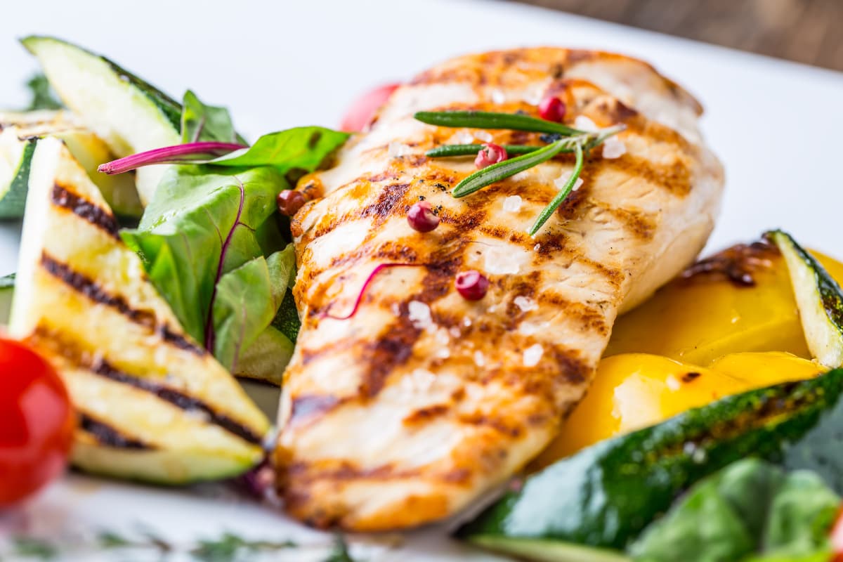Grilled chicken breast with avocado and side vegetables