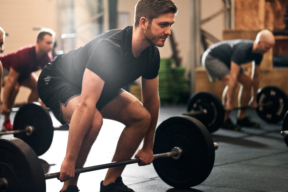 Man doing a deadlift as part of his workout routine to create a calorie deficit