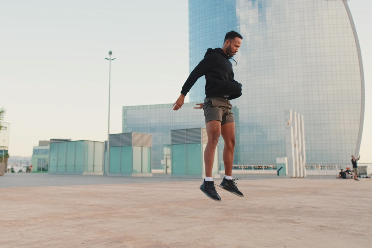 Man doing a jump squat while working out outside